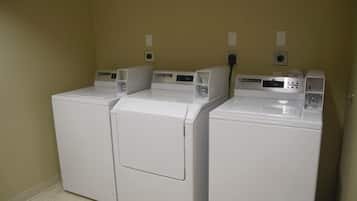 A laundry room with three stacked front-loading washing machines.
