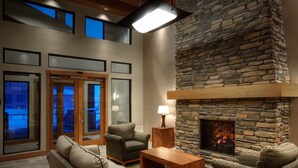 Un interior moderno con chimenea de piedra, asientos cómodos y ventanas amplias.