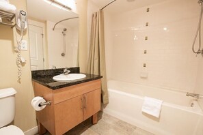 Un baño con lavamanos, inodoro y ducha.