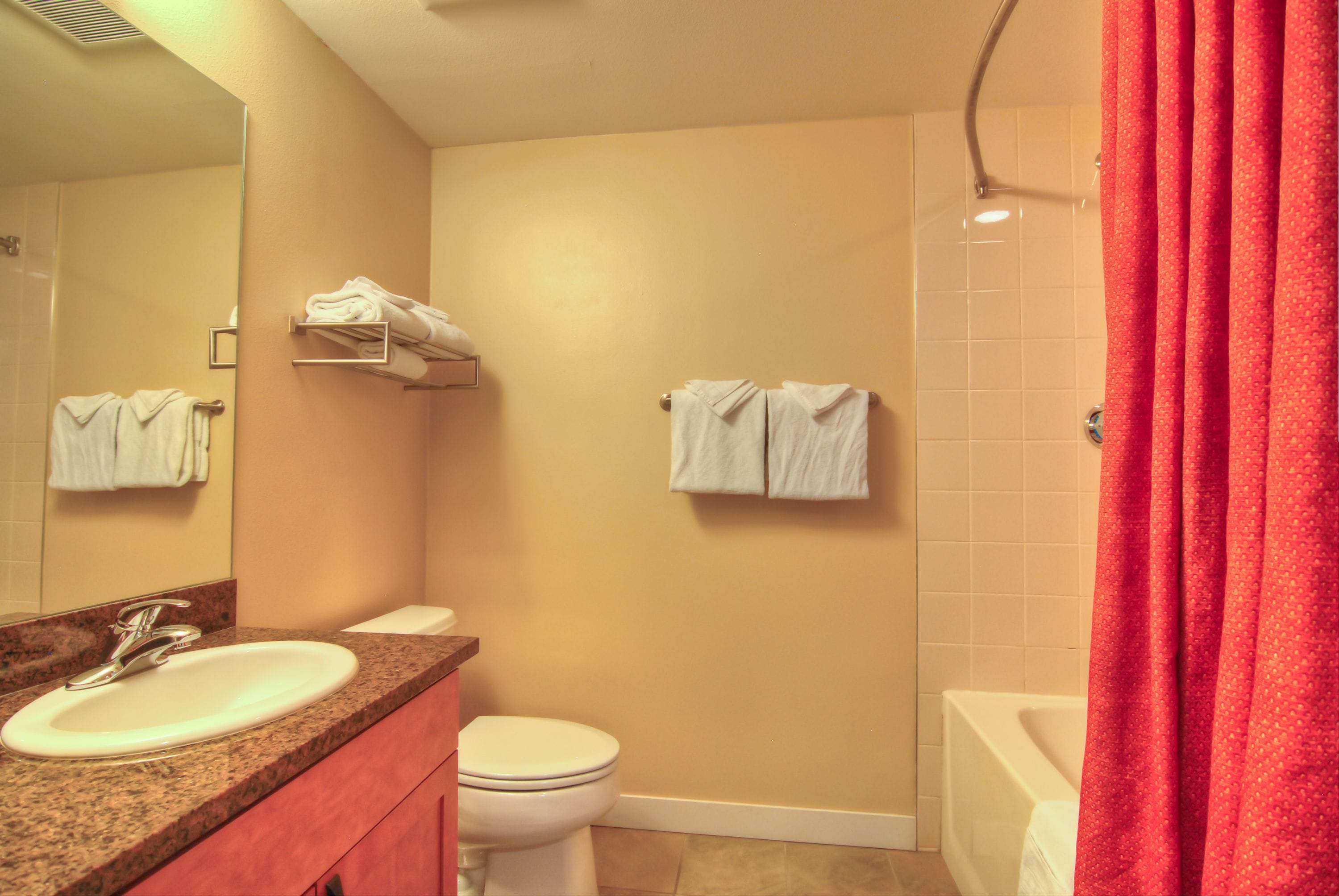 A bathroom with a sink, toilet, and shower.