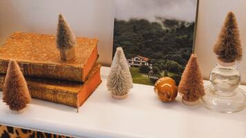 A shelf with decorative items including books, a framed picture, and small trees.