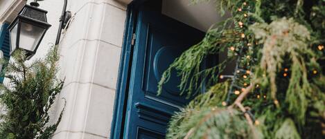 A building facade with a sign reading "Villa Des Rosiers" and a blue door.