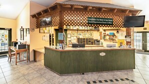 A reception desk with a sign for the Everglades City Motel & Ivy House Guest Registration/Check In Office.