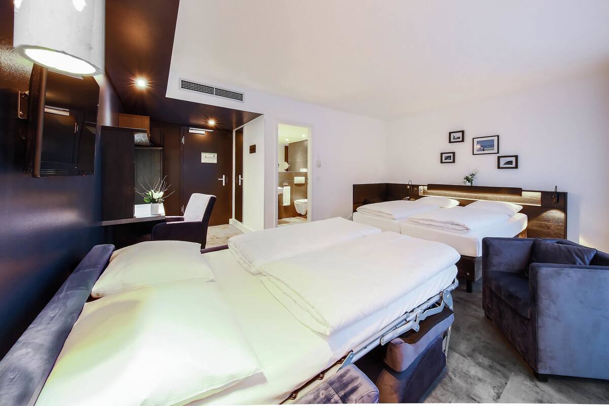Une chambre d’hôtel avec deux lits, un bureau et un canapé.