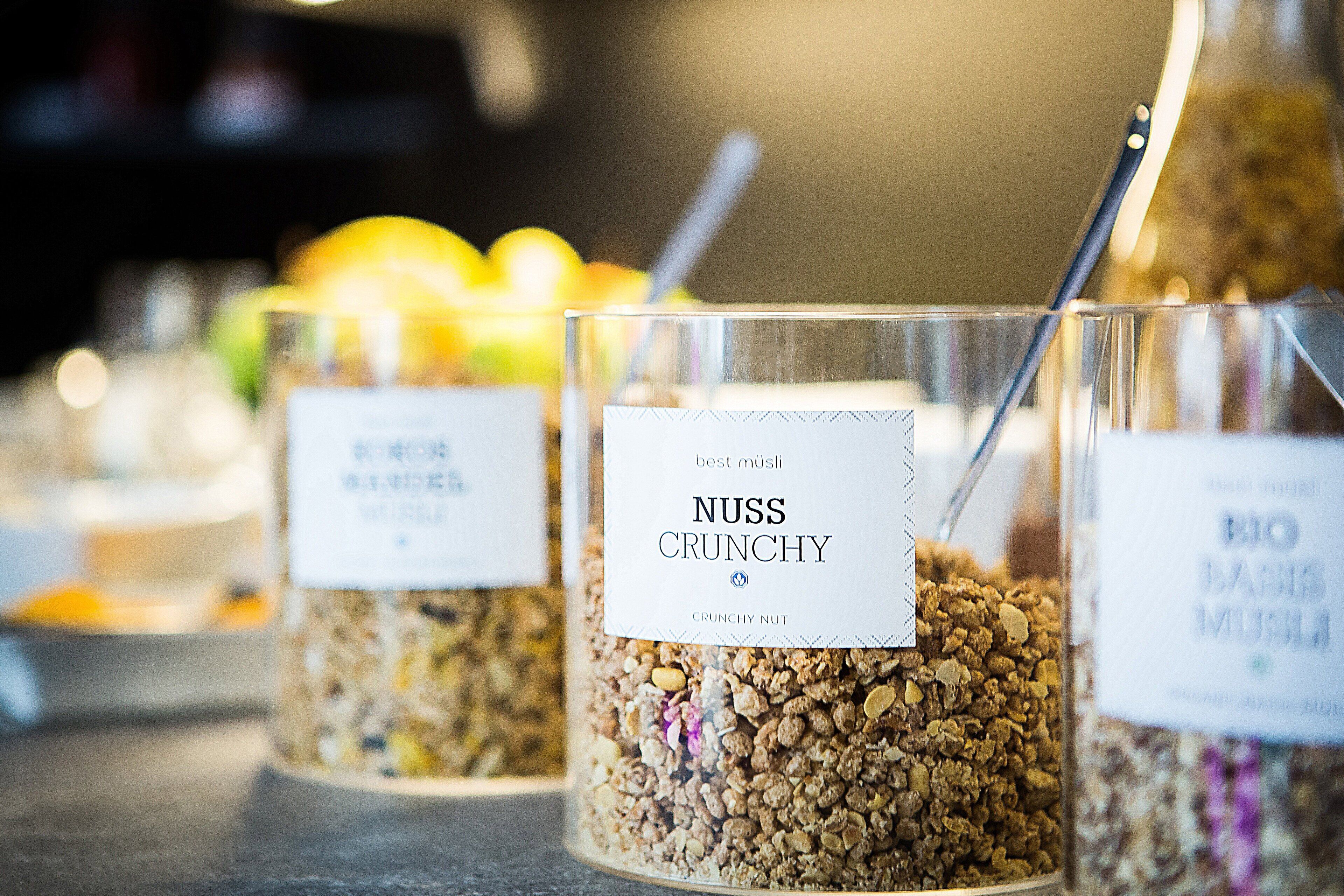 Diverses categories d'aliments, incloent un envàs amb l'etiqueta “NUSS CRUNCHY” i un altre amb l'etiqueta “BIO BARBE MUELE”.