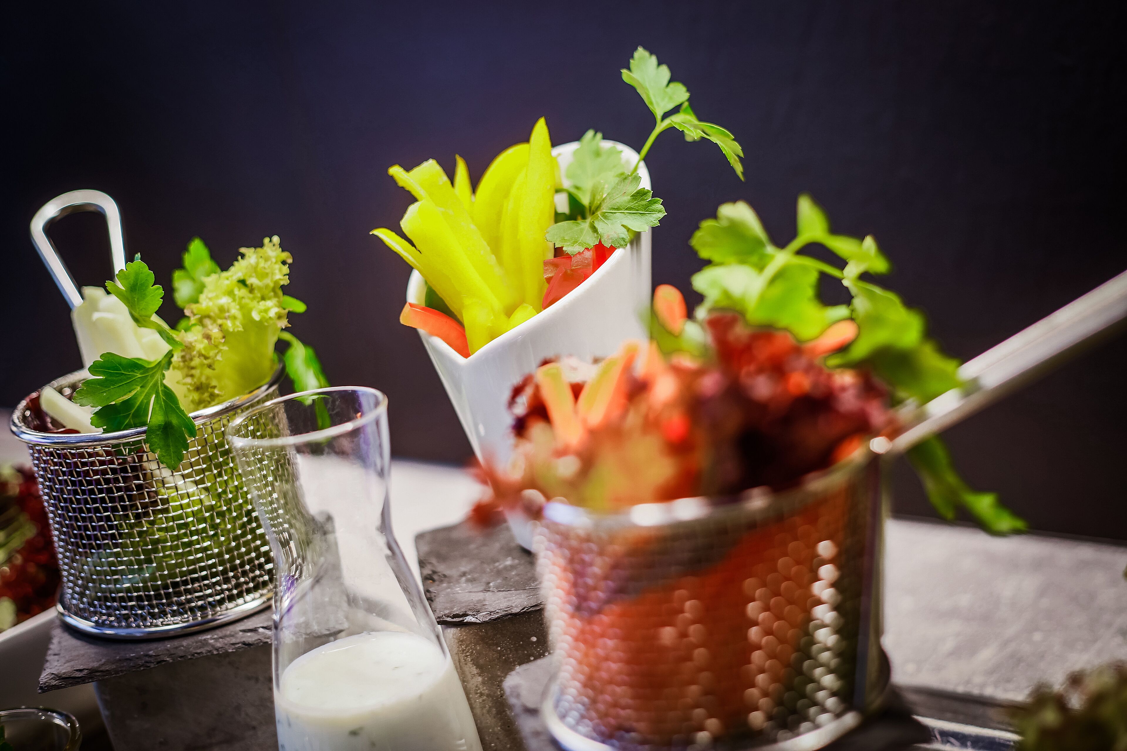 Primer plano de una presentación de comida con diversos vegetales y guarniciones.