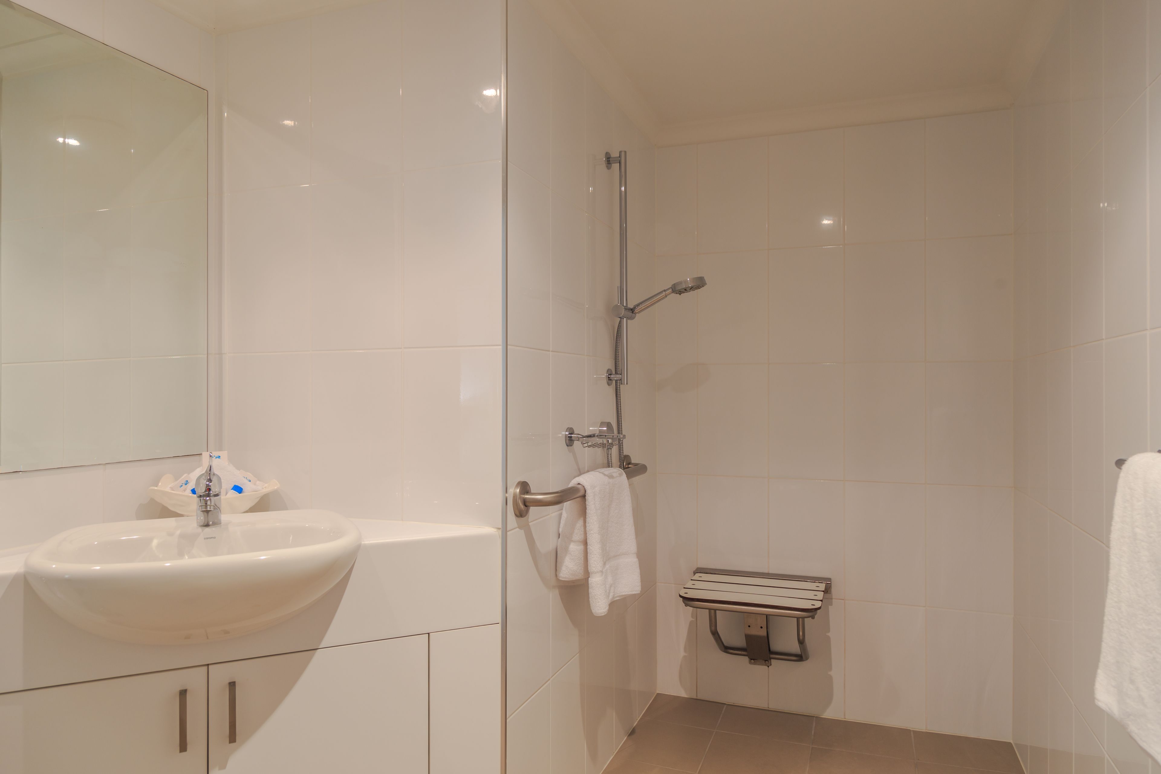 Une salle de bain moderne avec un lavabo blanc, une baignoire et une cabine de douche en verre.
