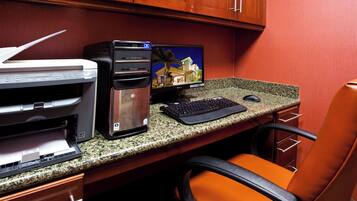 A home office setup with a desktop computer, monitor, keyboard, mouse, and printer on a granite countertop.