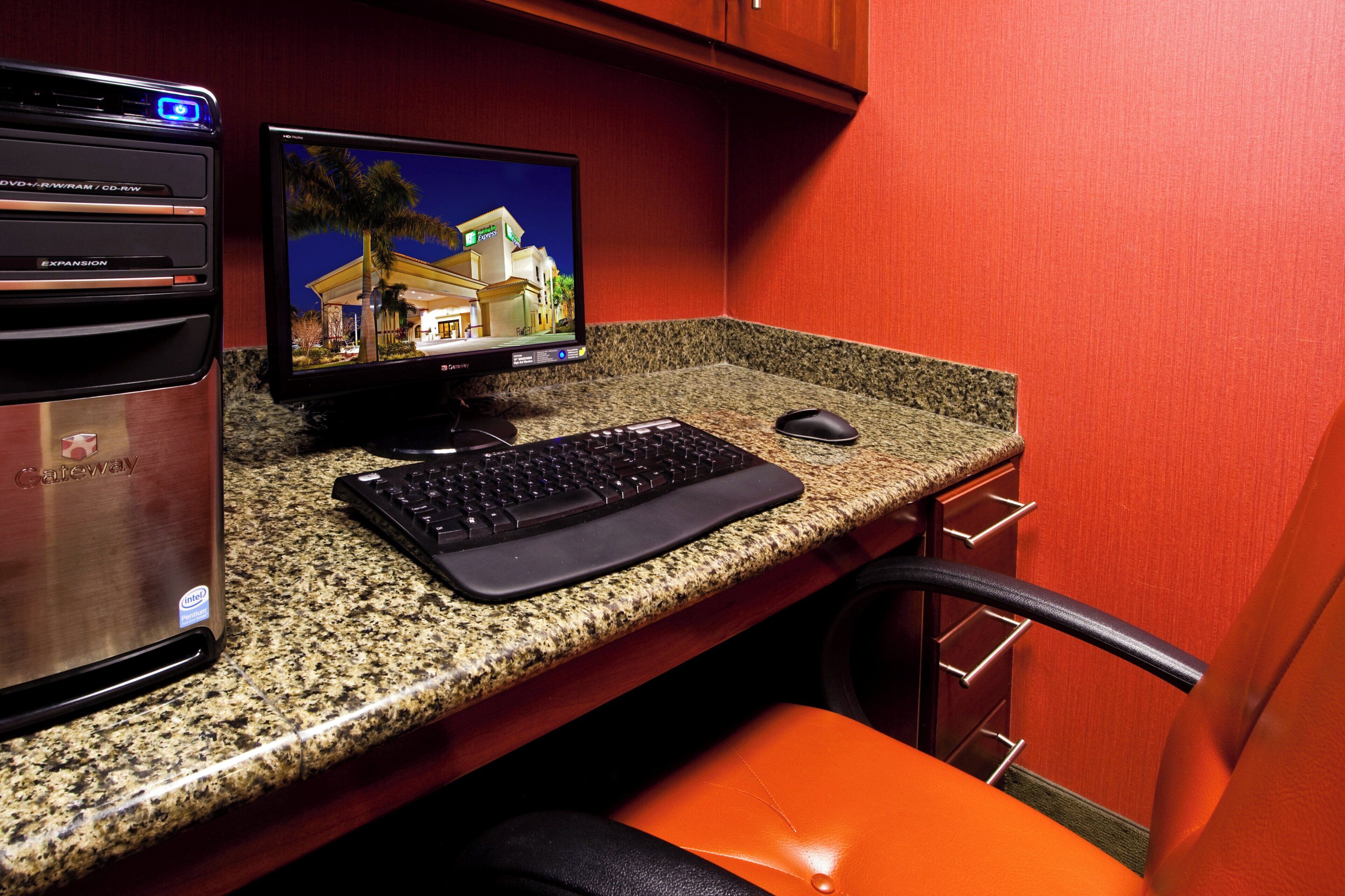 A computer desk with a monitor, keyboard, and mouse.