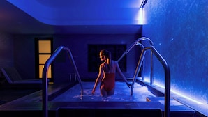 A person in a red swimsuit in a swimming pool with metal railings and a tiled floor. - Hotel Ivy, a Luxury Collection Hotel, Minneapolis (Minneapolis)