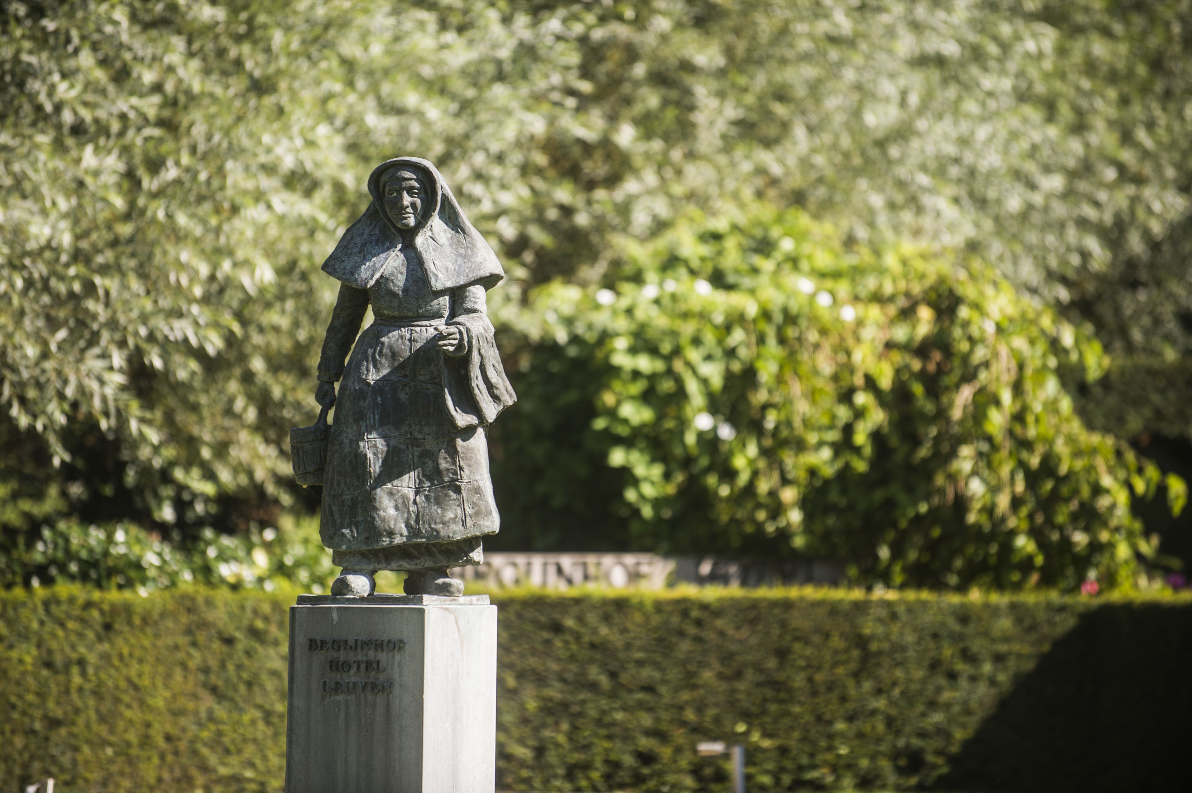 Una estatua de una mujer sobre un pedestal con una placa que dice "HOTEL LUNY – INICIO".