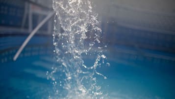 Una piscina al aire libre de temporada, sillones reclinables de piscina