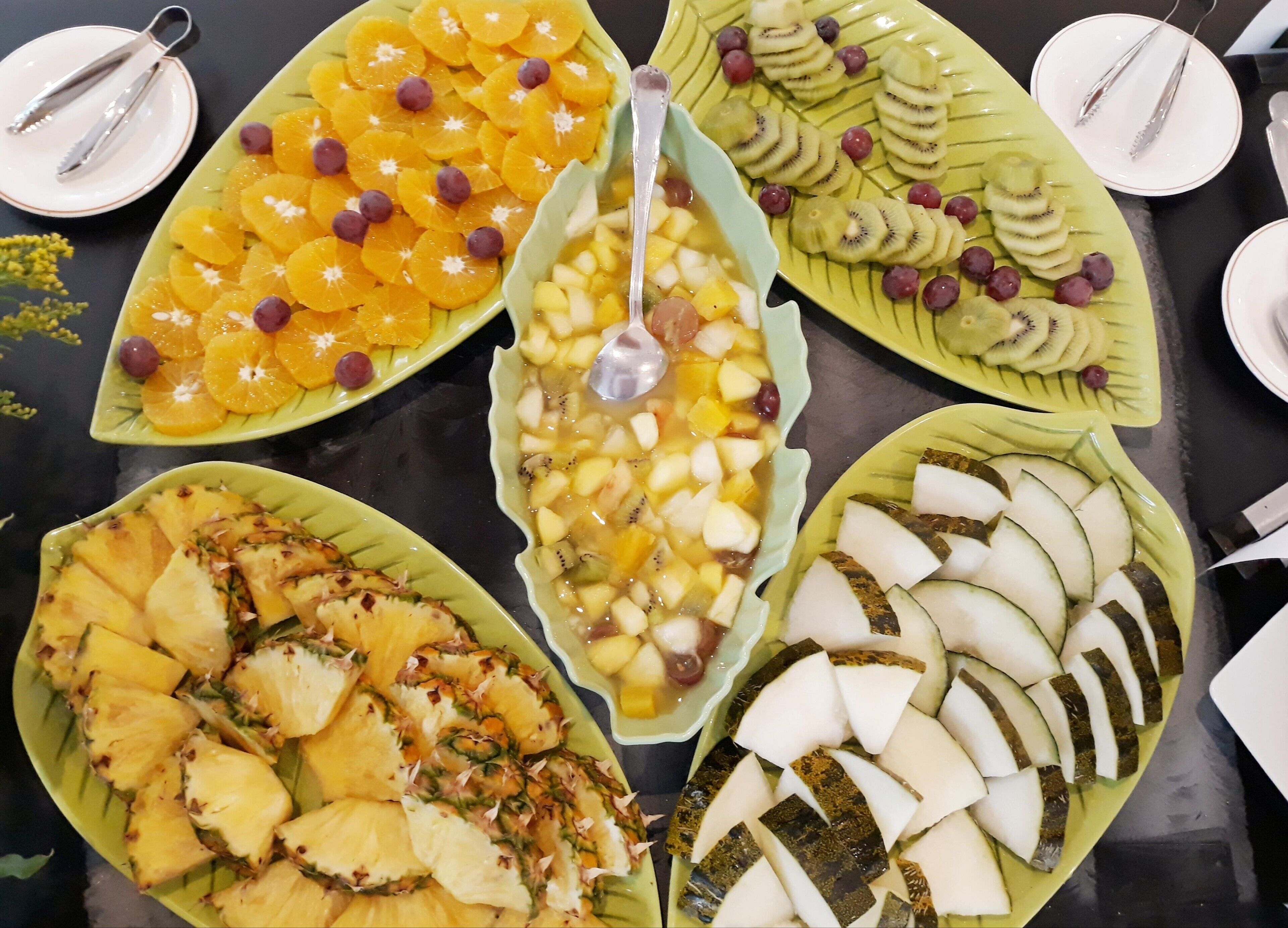 A buffet table with various fruit platters.