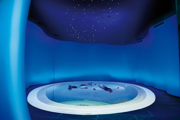 Un jacuzzi circular con piso de malla, rodeado de paredes de color azulado.