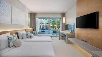 A modern hotel room with two beds, a desk, a flat-screen TV, and a view of a pool and outdoor area.