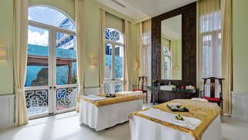 A hotel room with two beds, a large mirror, and a view of a blue building.