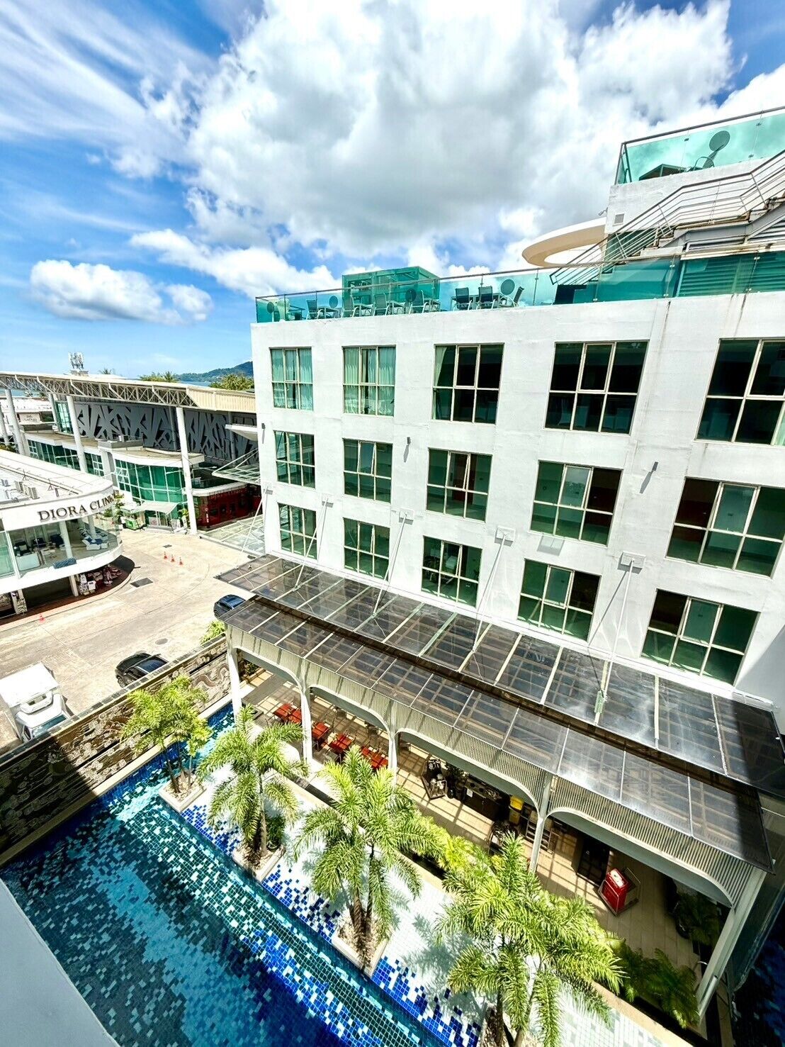 A modern hotel with a rooftop pool, a restaurant, and a visible Dior Clinic.