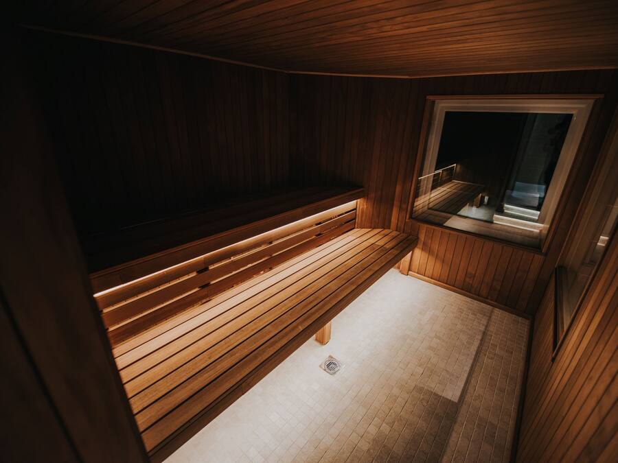A wooden sauna with a bench and a window.