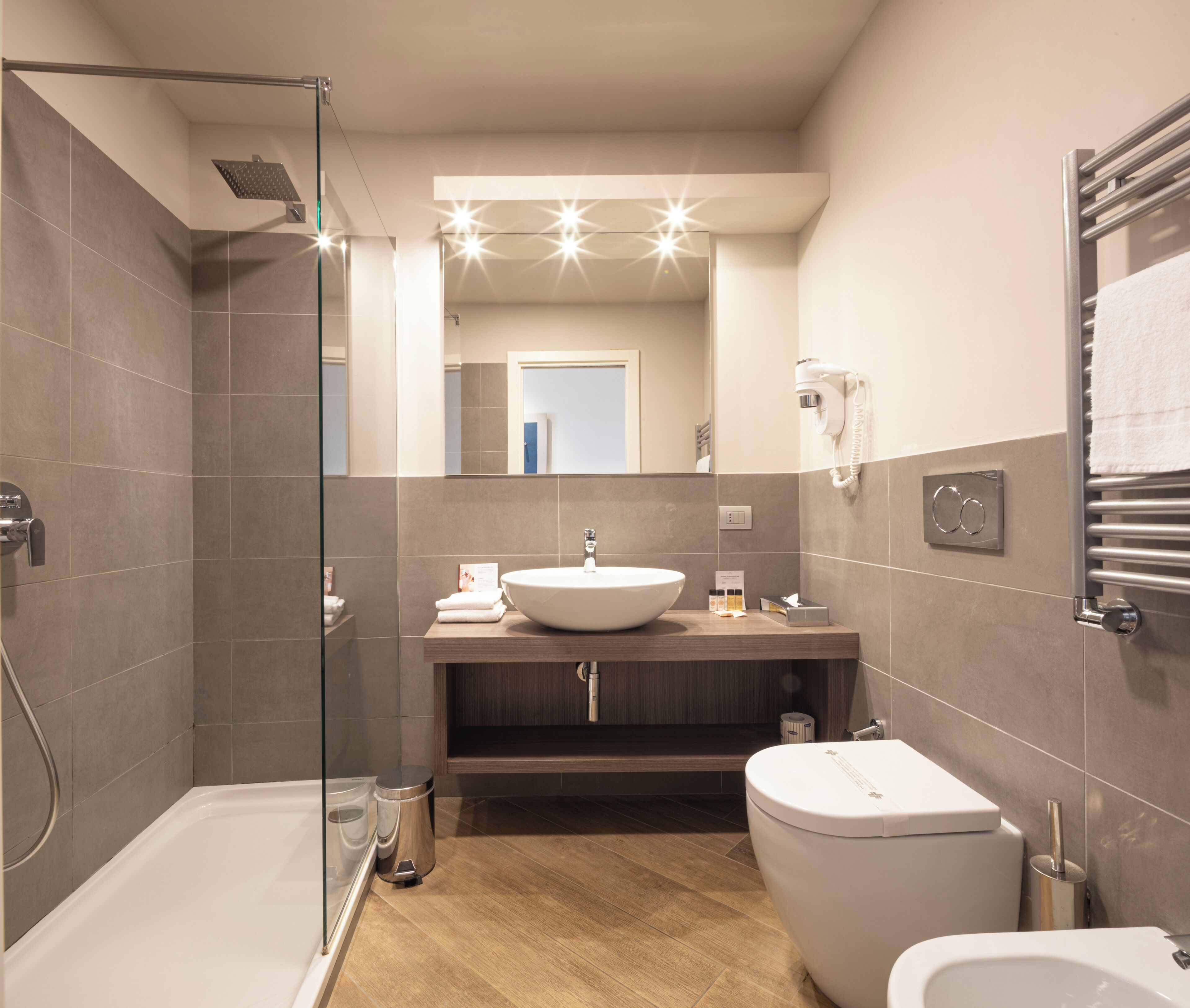 Un baño moderno con cabina de ducha de vidrio, tocador con lavabo, inodoro y bidé.