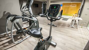 A gym with various exercise equipment including an elliptical and a stationary bike.