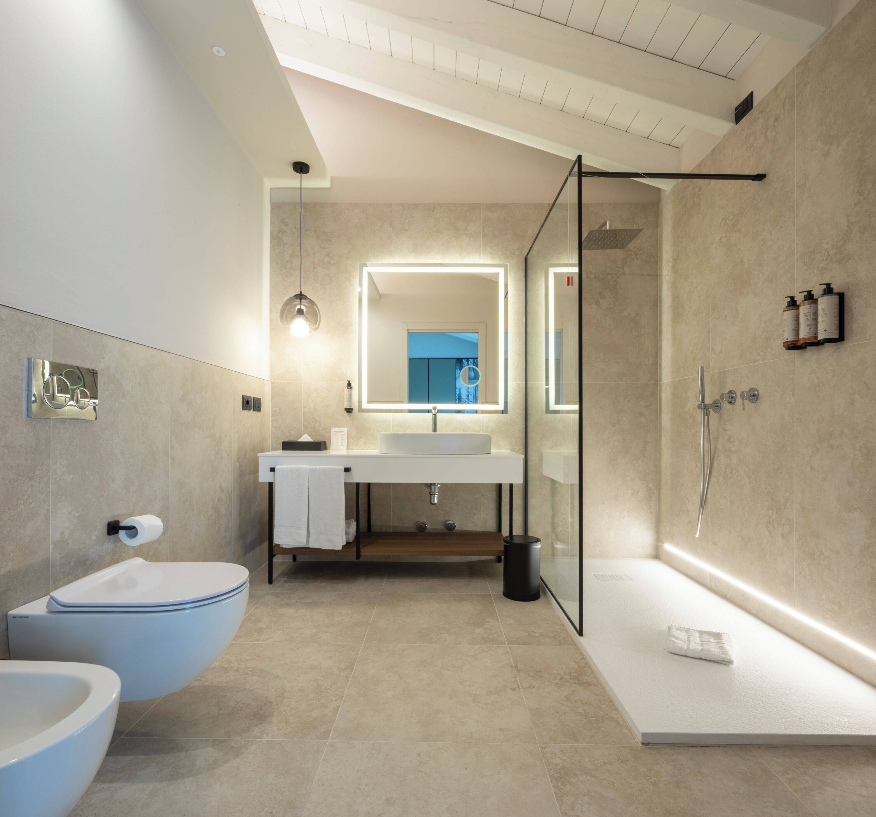 A modern bathroom with a freestanding bathtub, a glass-enclosed shower, and a large mirror.