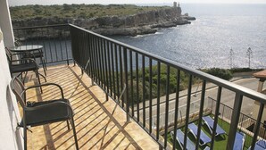 A balcony with a view of the sea, a table, and chairs. - Hotel Rocamar (Santanyi)