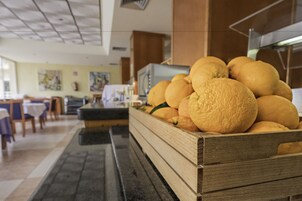 A wooden crate filled with oranges in a hotel lobby.