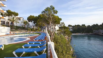 Piscine extérieure, parasols de plage, chaises longues