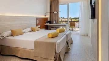 Una habitación de hotel con una cama grande, un escritorio, una silla y un televisor.