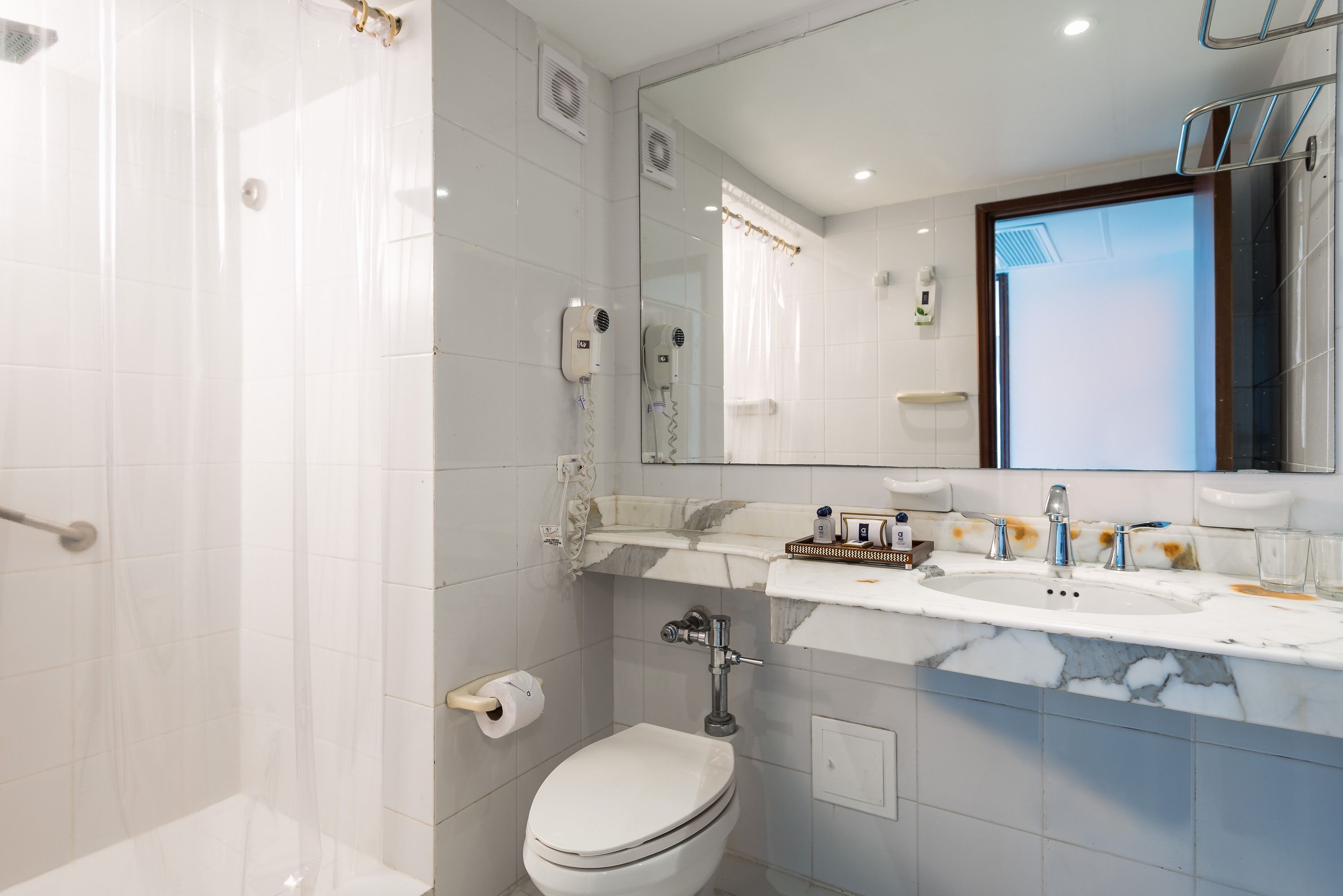 A modern bathroom with a shower, toilet, and sink.