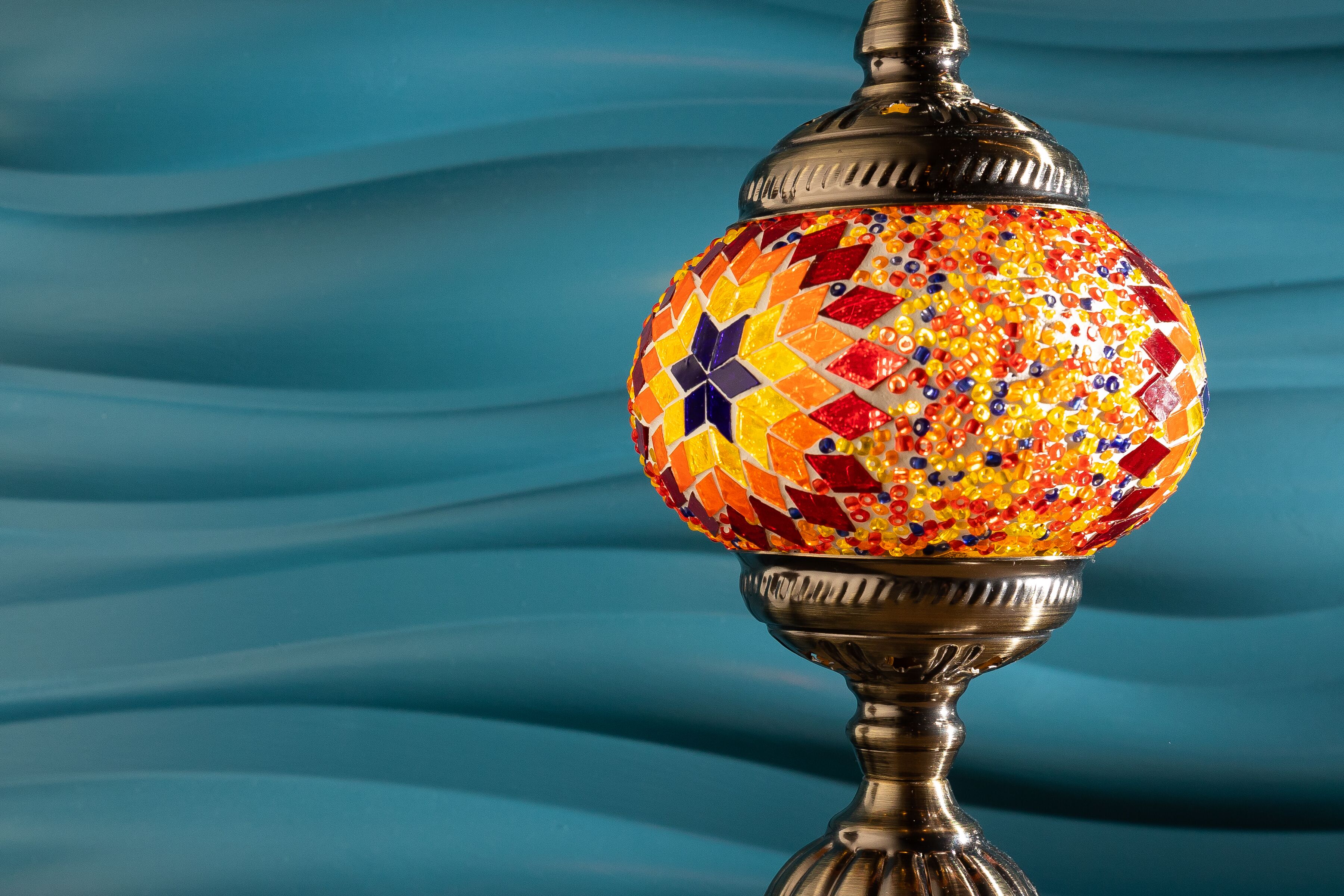A decorative lamp with a mosaic design on a metal stand.