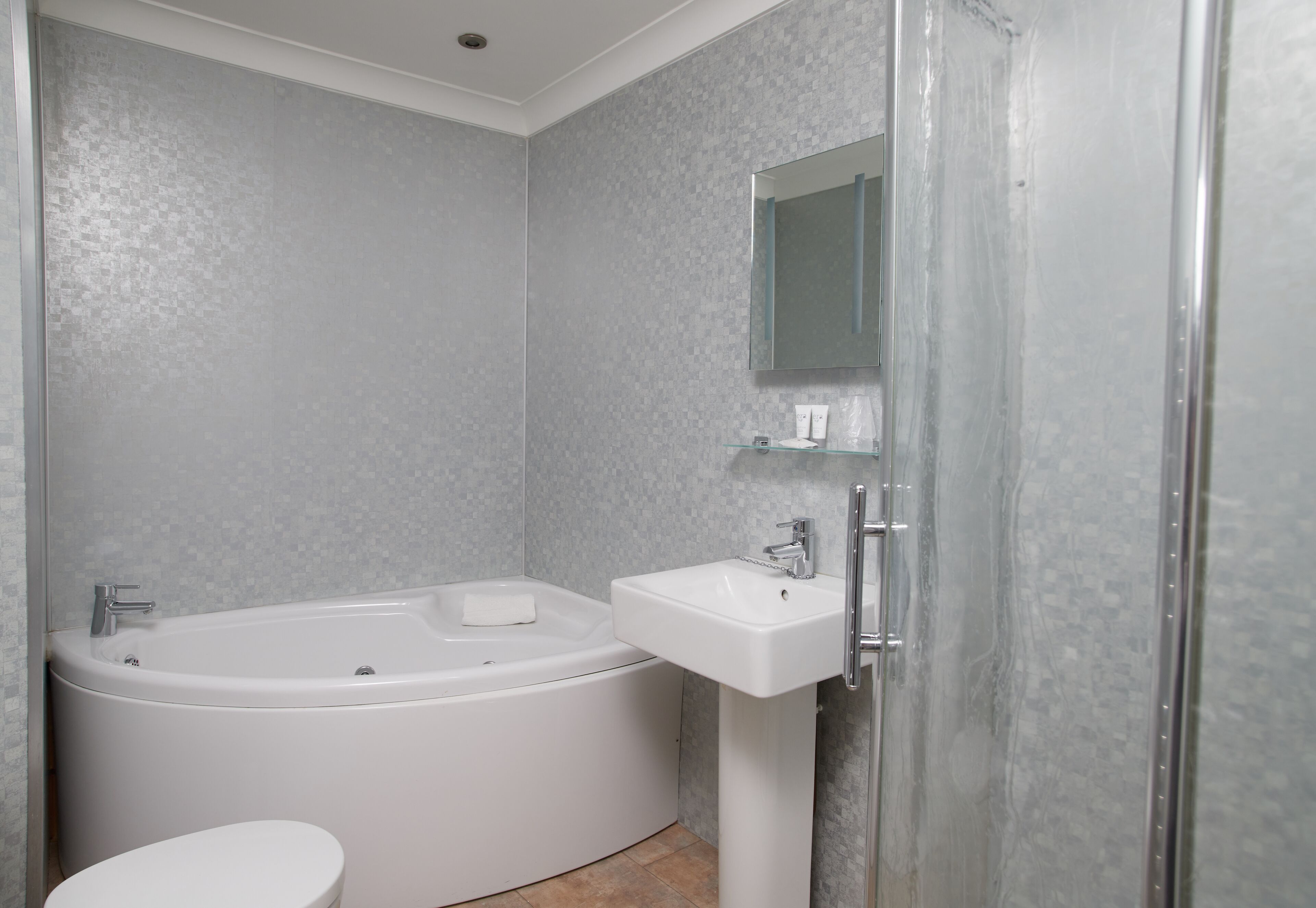 Un baño moderno con bañera, lavamanos e inodoro.