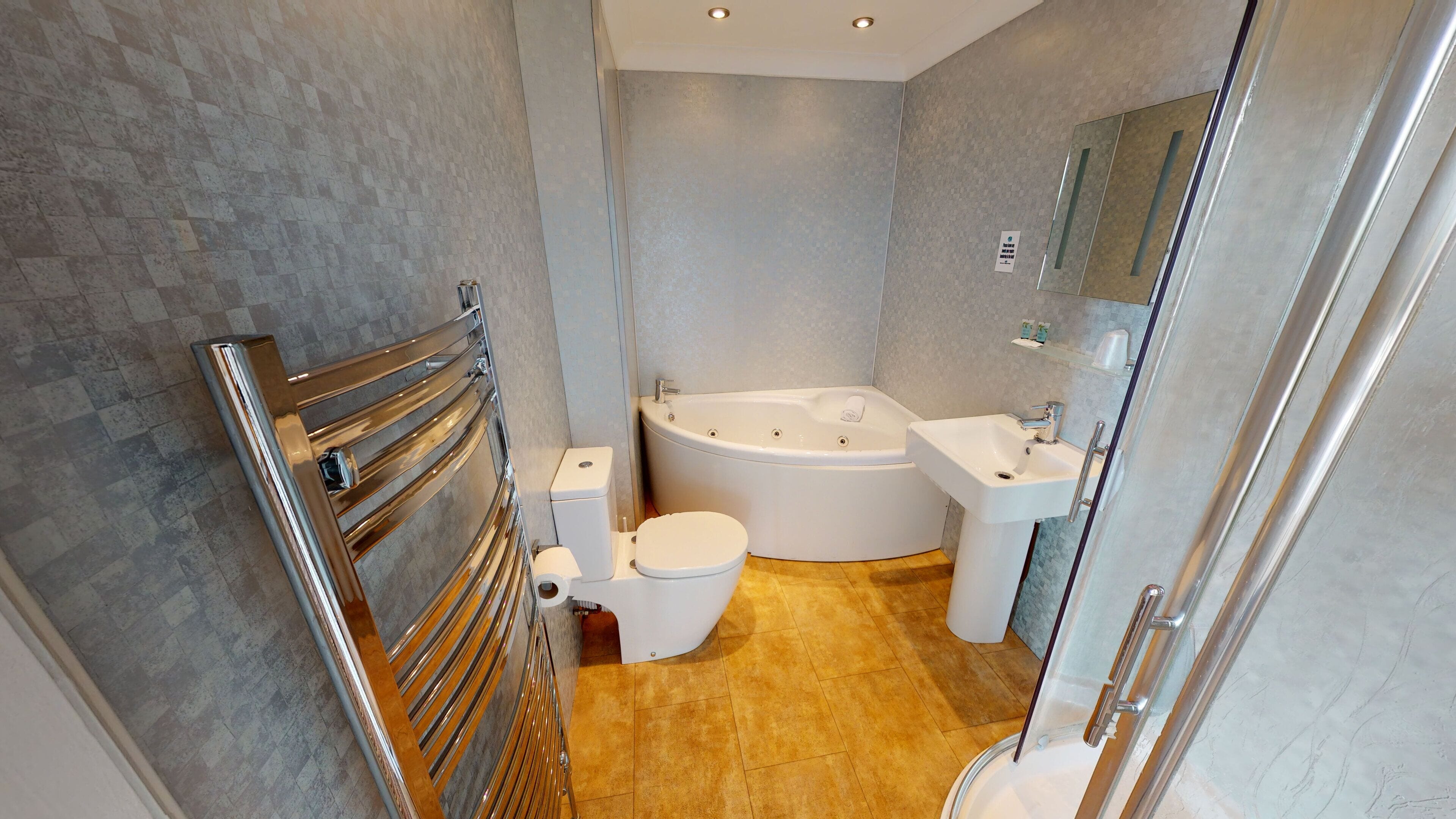 Un bany modern amb una dutxa de vidre, una banyera independent, un vàter i un lavabo.