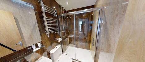 A modern bathroom with a glass-enclosed shower, a toilet, and a sink.