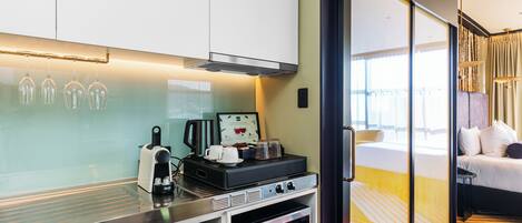 Una cocina moderna con cafetera, tetera y microondas.