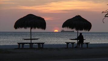 On the beach, white sand, sun-loungers, beach towels