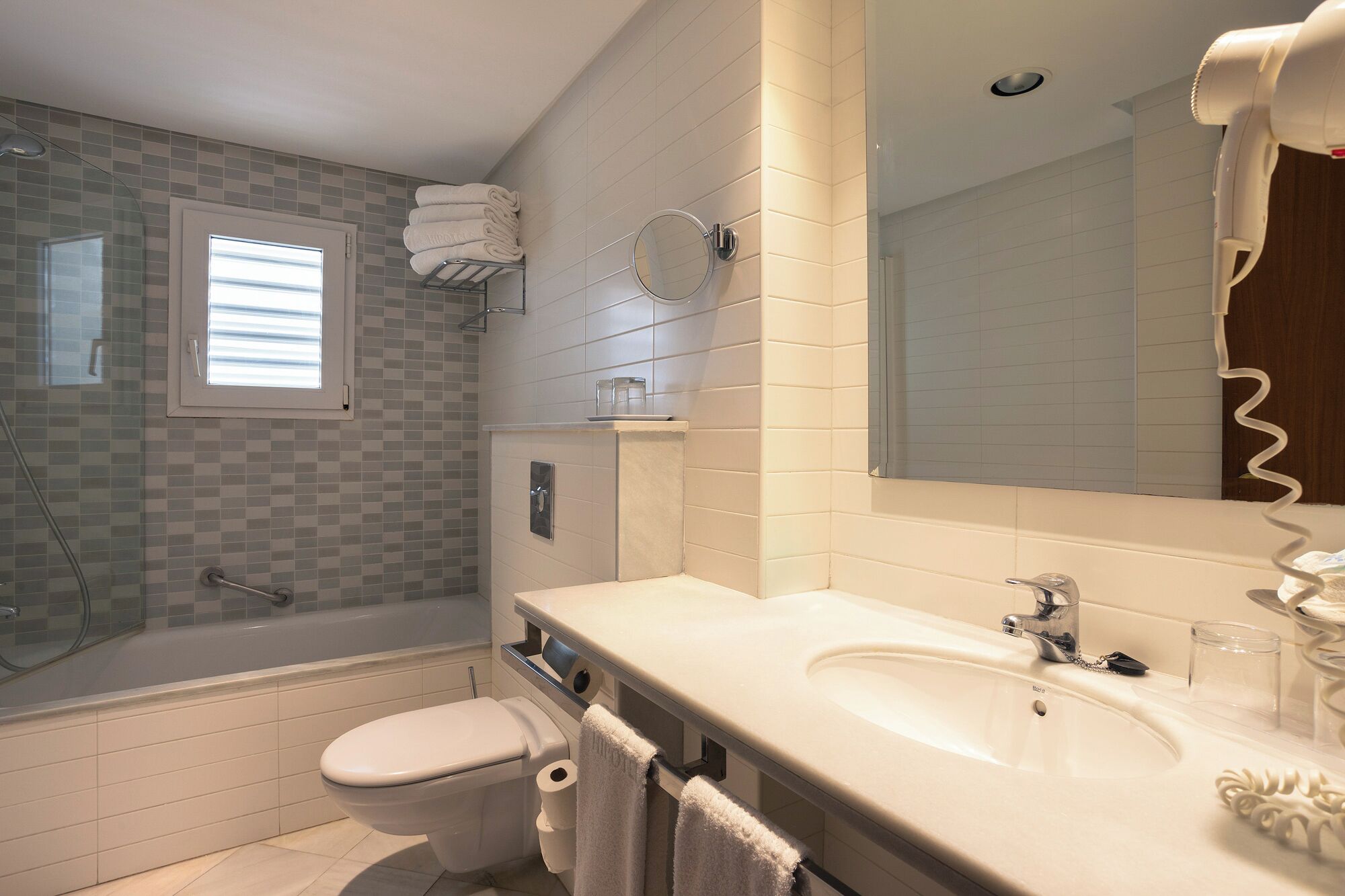 A modern bathroom with a bathtub, toilet, and sink.