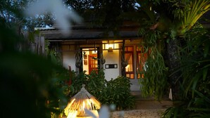 A traditional house with a thatched roof, a stone pathway, and lush greenery. - Bangtao Beach Chalet (Choeng Thale)