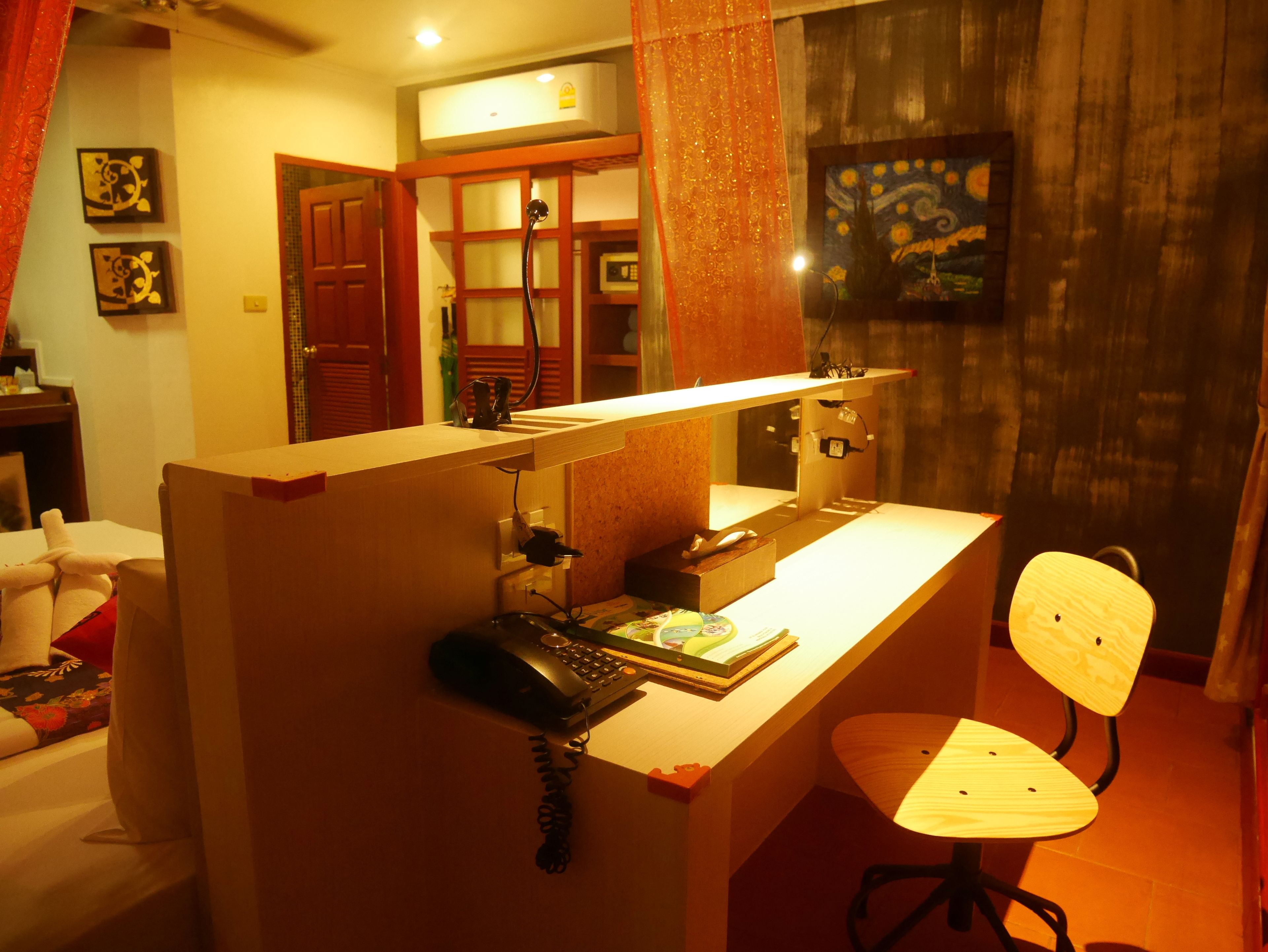 A compact workspace with a desk, chair, and a telephone.