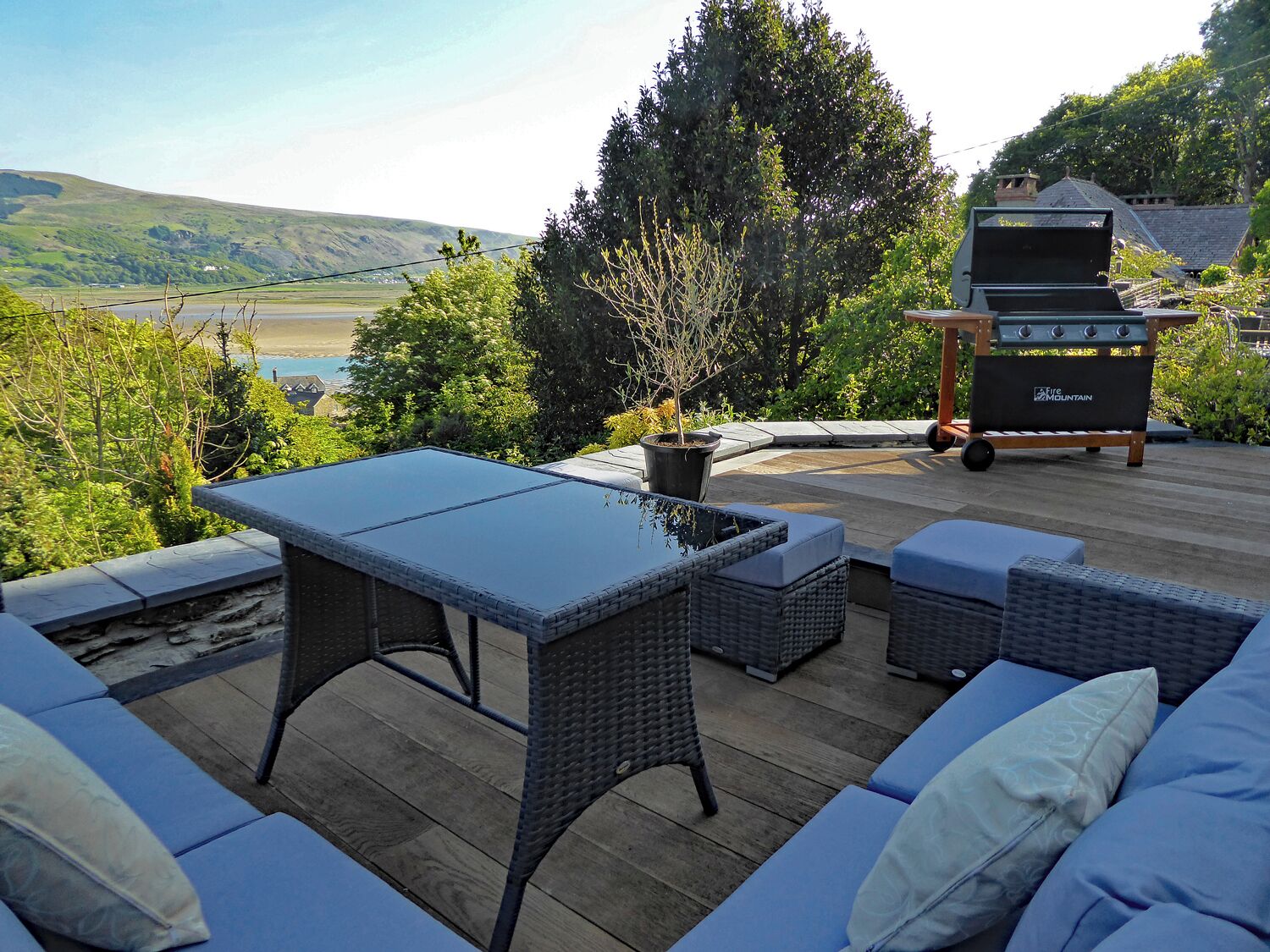 An outdoor patio with a table and seating, overlooking a scenic landscape.