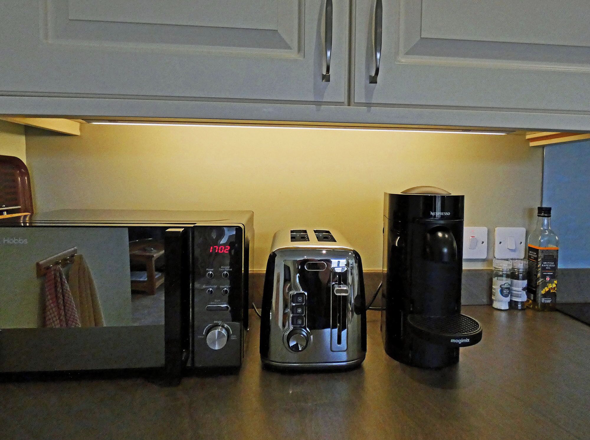 A kitchen with a toaster, a coffee maker, and a kettle.