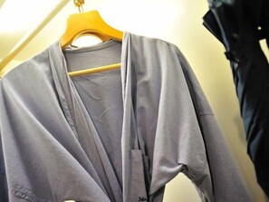 Een grijze cardigan hangt aan een houten kleerhanger.