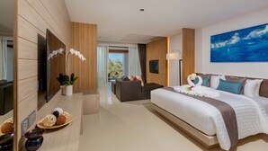 A modern hotel room with a large bed, a sofa, a TV, and a view of the outdoors. - Kudo Hotel (Patong)