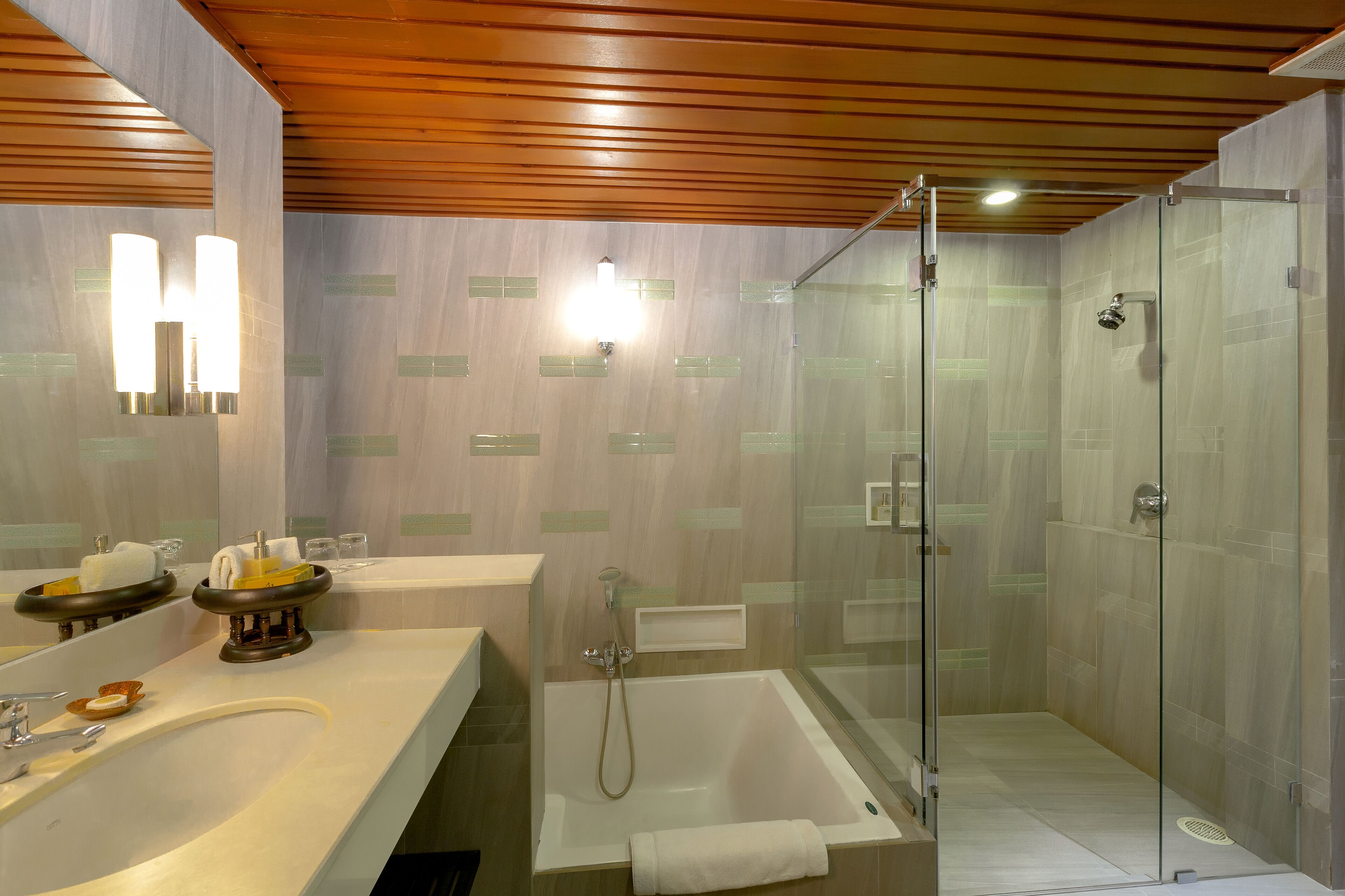A modern bathroom with a glass-enclosed shower, a bathtub, and a vanity with a mirror and towel racks.