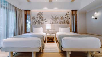 A hotel room with two beds, a nightstand, a wall-mounted lamp, and a large window with curtains.