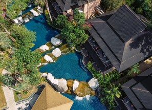 Vista aérea de un resort con piscina, formaciones rocosas y vegetación circundante.