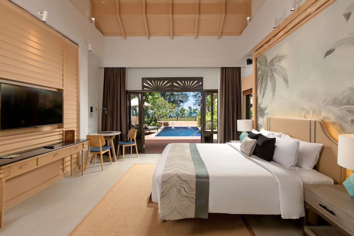 Une chambre d’hôtel moderne dotée d’un grand lit, d’une télévision, d’un bureau et offrant une vue sur une piscine.