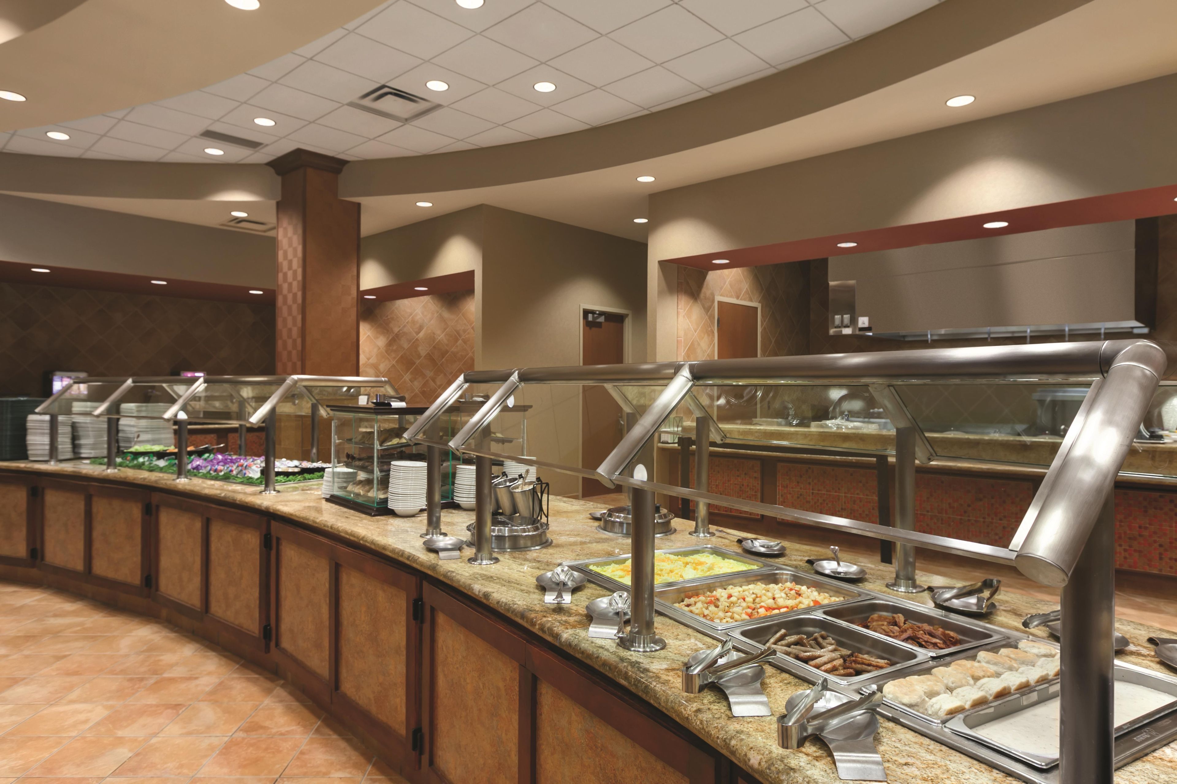 Un buffet avec plusieurs présentoirs de plats et des ustensiles de service.