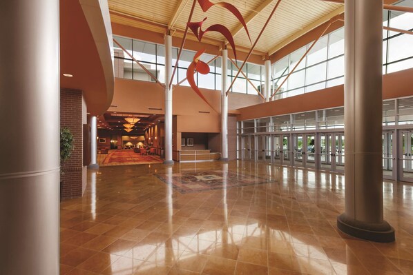 A spacious lobby with a polished tile floor, large columns, and a high ceiling with natural light. - Embassy Suites Omaha-La Vista/Hotel & Conference Center (La Vista)