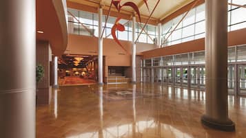 A spacious lobby with a high ceiling, large windows, and a central column.